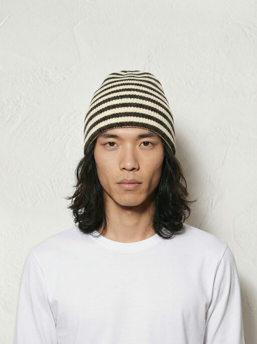 AI model facing the camera in a cream and brown striped beanie and white tee, generated with Veeton