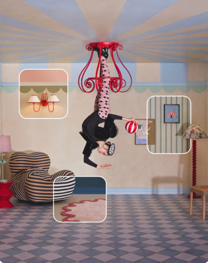 Acrobat in black hanging upside down from a red chandelier in a circus-striped pastel room with retro furniture