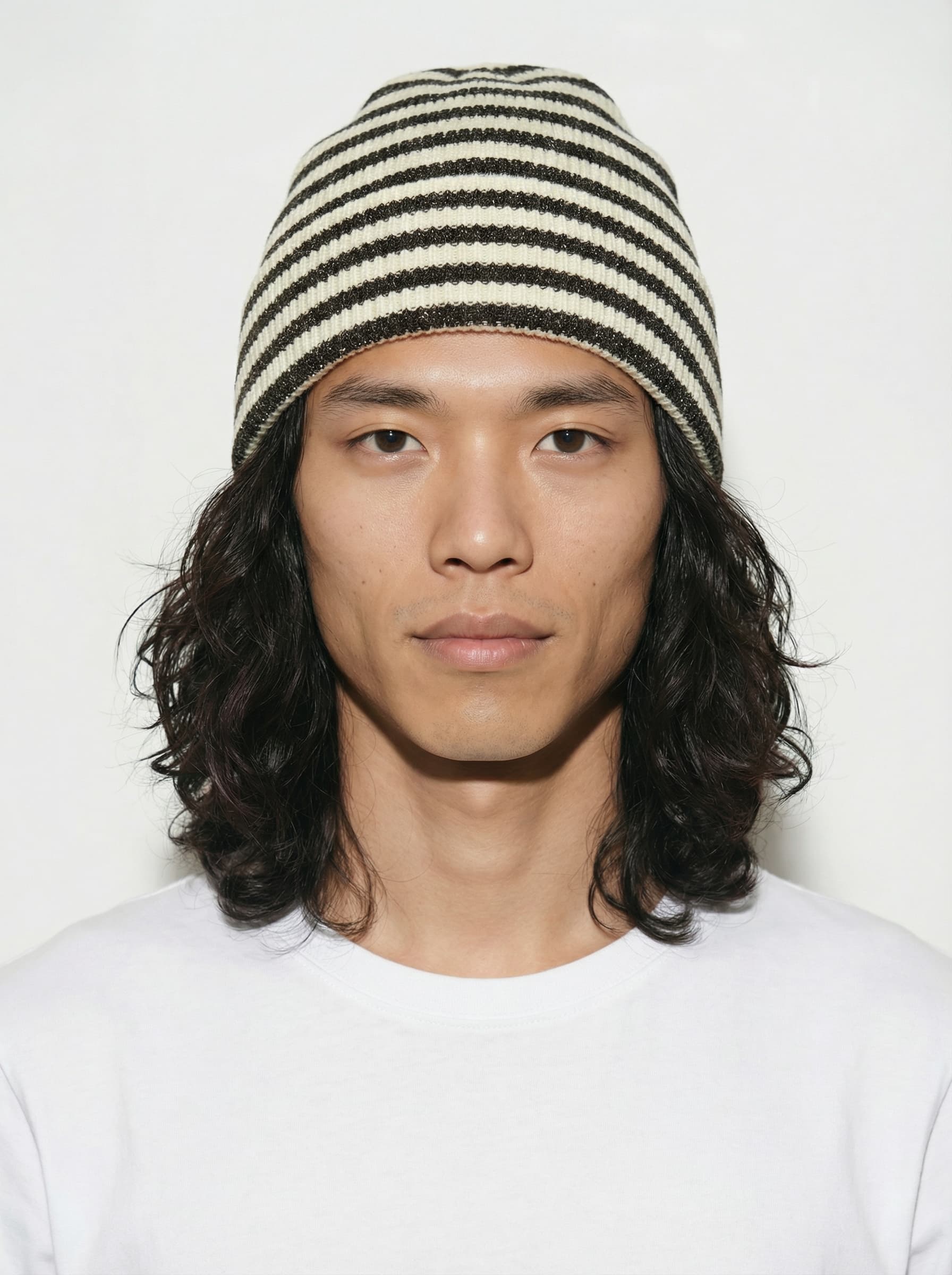 AI model with long curly hair wearing a cream and brown striped beanie, generated with Veeton