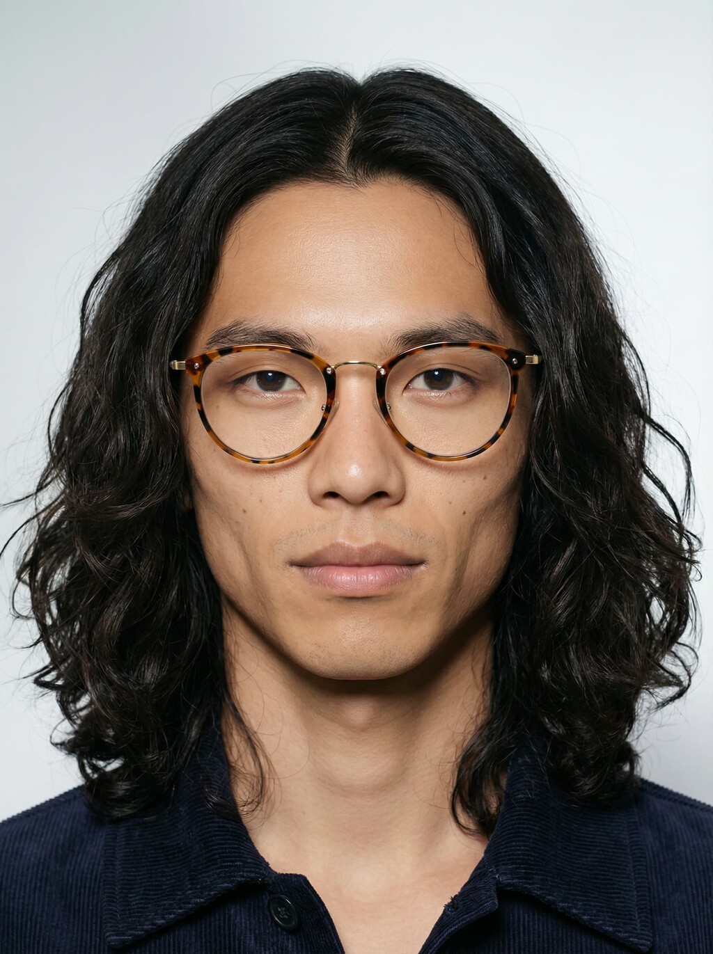 AI model facing the camera in round tortoiseshell glasses and navy corduroy shirt, generated with Veeton