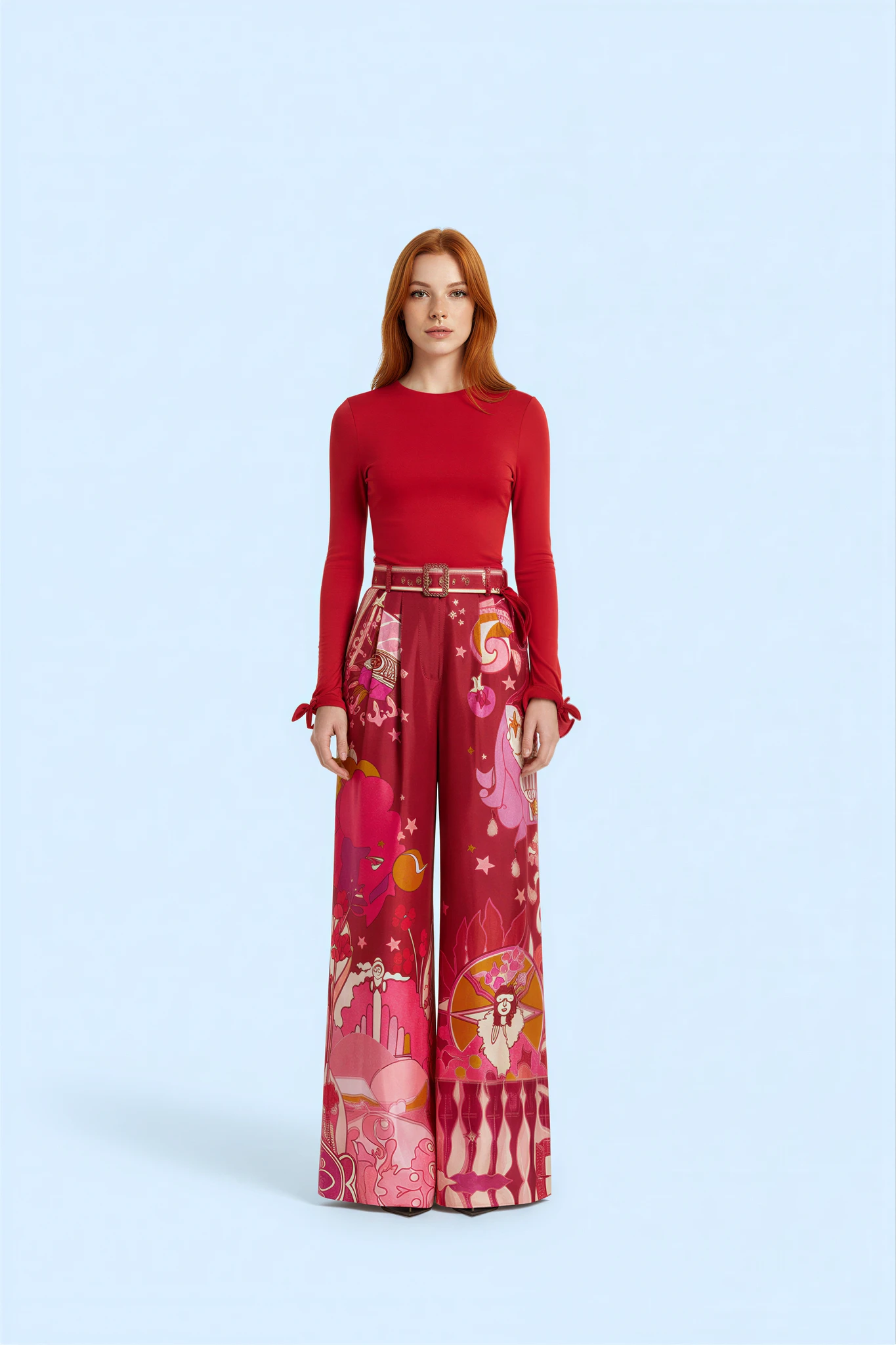 AI model with red hair in a red long-sleeve top and printed pink wide-leg trousers on a light blue background