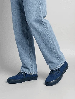 AI model in light blue jeans stepping forward in navy canvas sneakers, generated with Veeton
