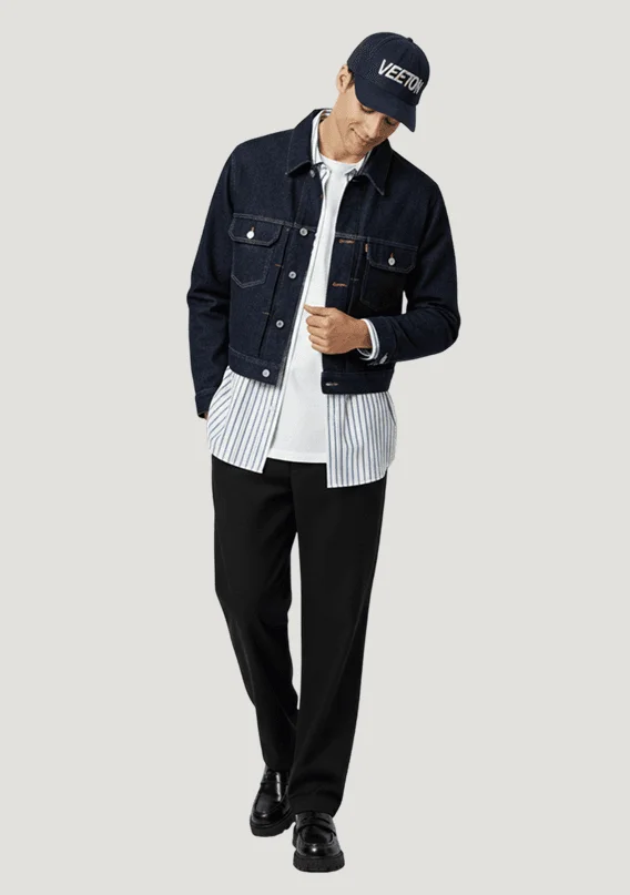 AI male model in an indigo denim jacket and Veeton cap looking down mid-stride, generated with Veeton