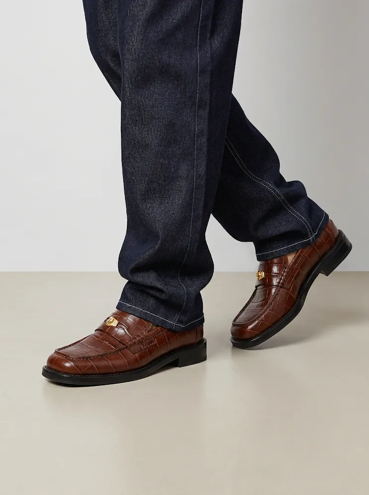 AI model in dark denim wearing brown croc-embossed penny loafers, generated with Veeton