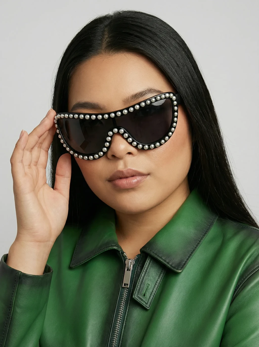 AI model in a green leather jacket wearing pearl-studded black shield sunglasses, generated with Veeton