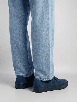 AI model in light blue jeans wearing navy canvas sneakers seen from the side, generated with Veeton