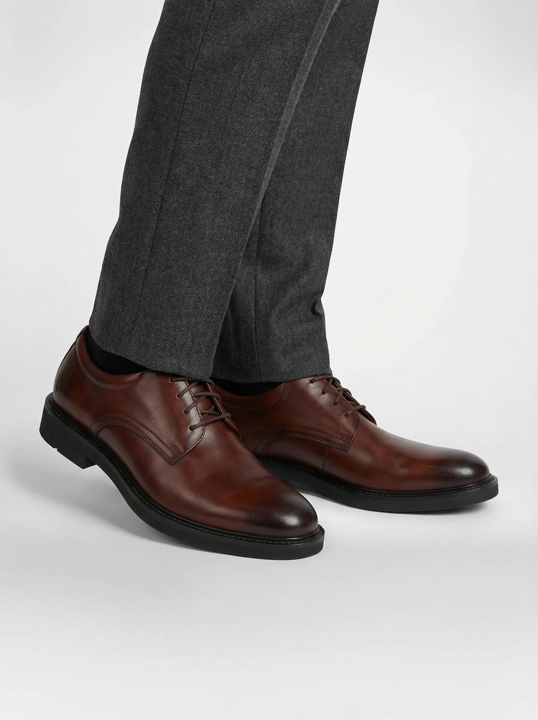 Brown leather derby shoes worn with grey wool trousers on an AI model, generated with Veeton